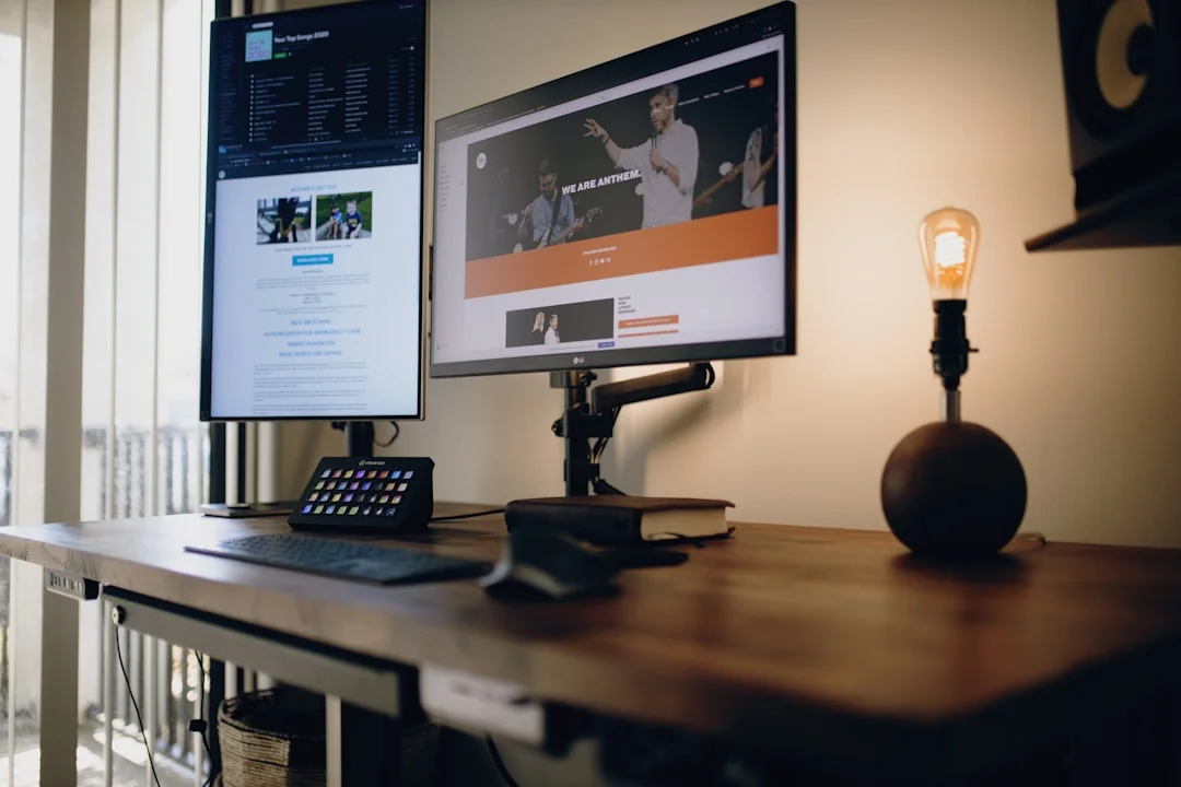 A person works on digital design in a home office, using a laptop and a graphic tablet.